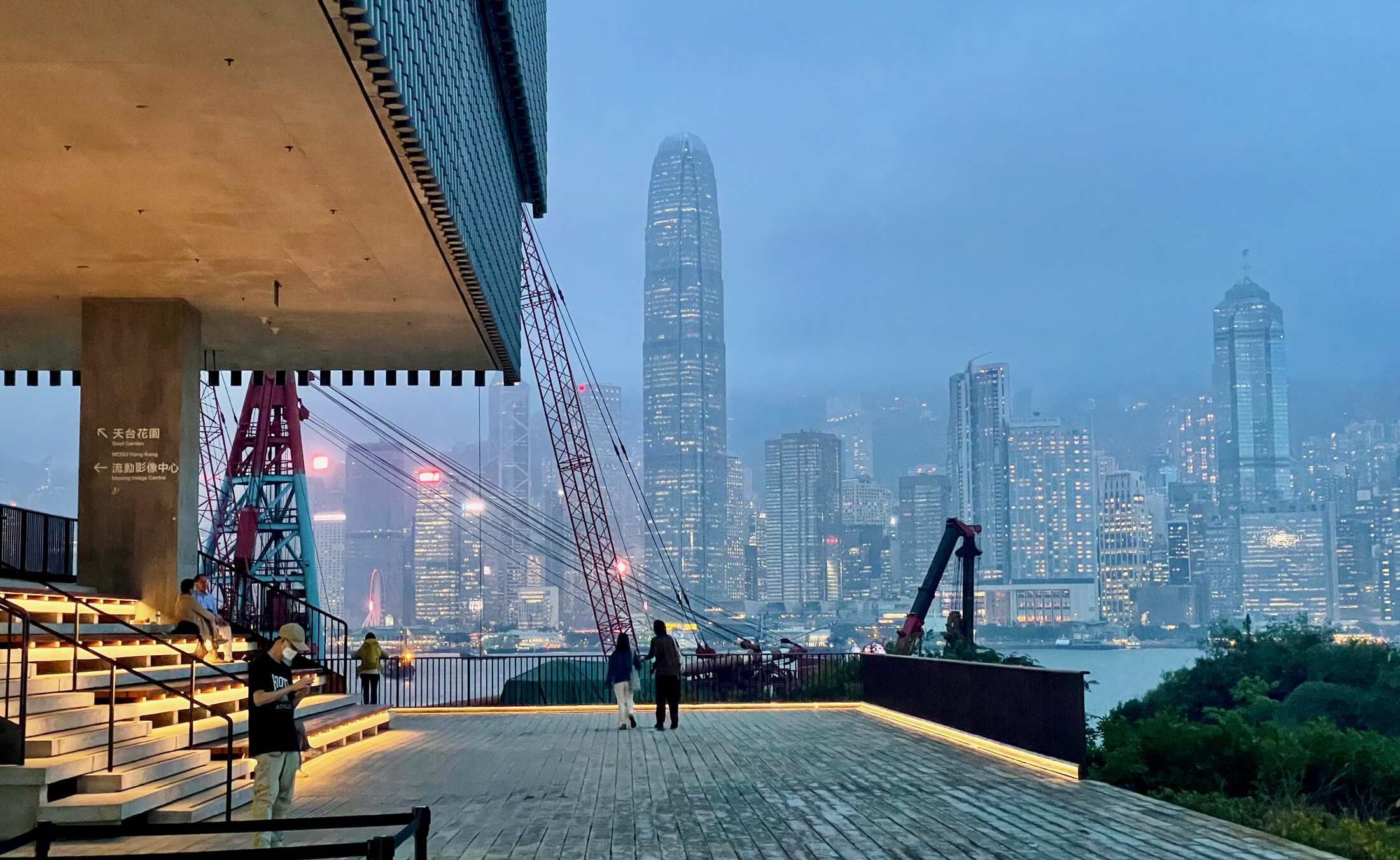 A couple looking at a boat in front of Hong Kong Central from West Kowloon Art District