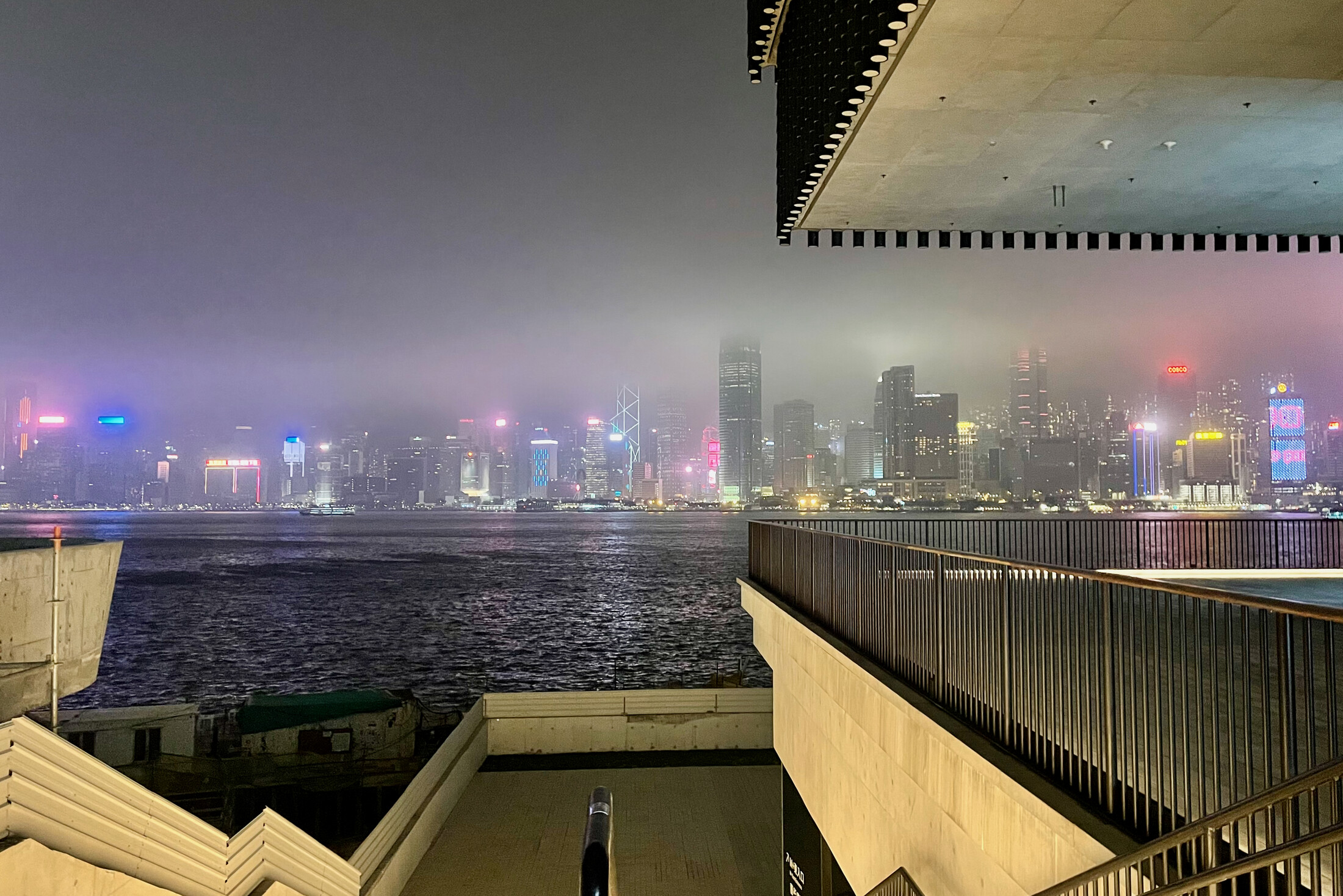 Misty cyberpunk Hong Kong Island as seen from Kowloon
