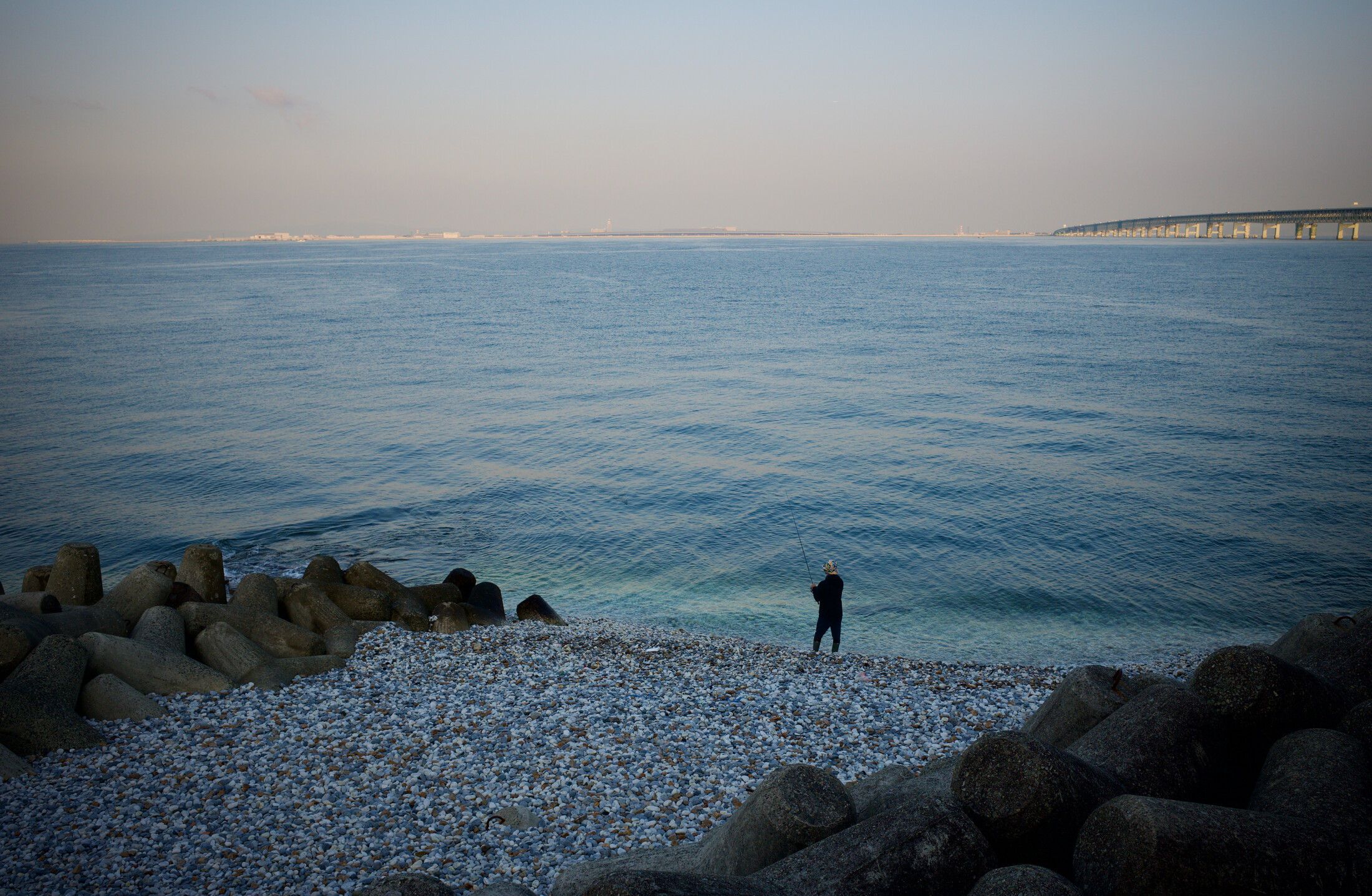 A fisherman looking at the bridge to Kansai airport